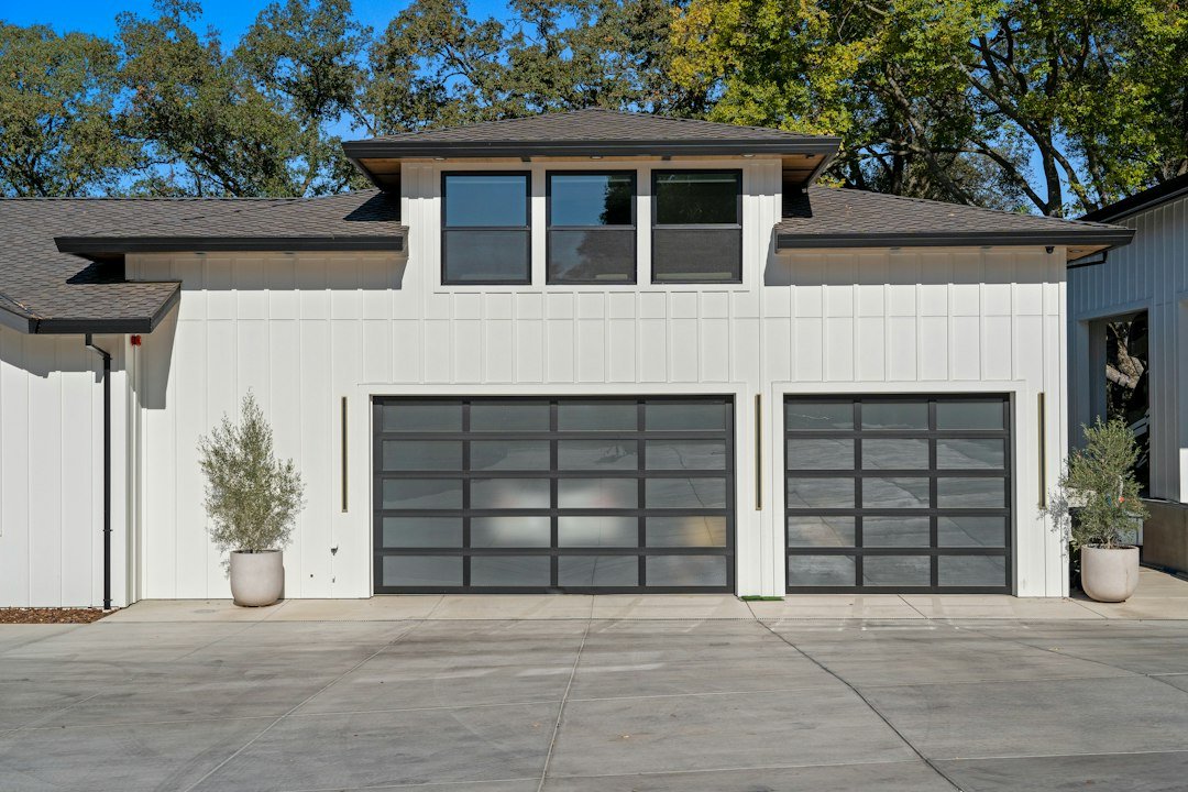 Glass panel garage doors on a white home